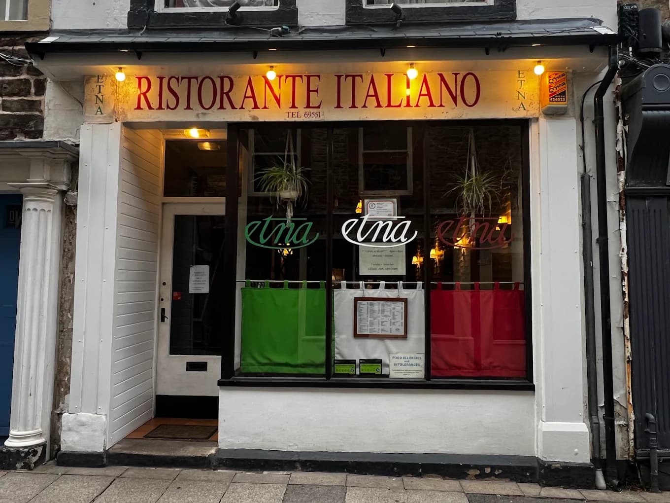 The front of Etna Ristorante Italiano on New Street, Lancaster, lit up at dusk